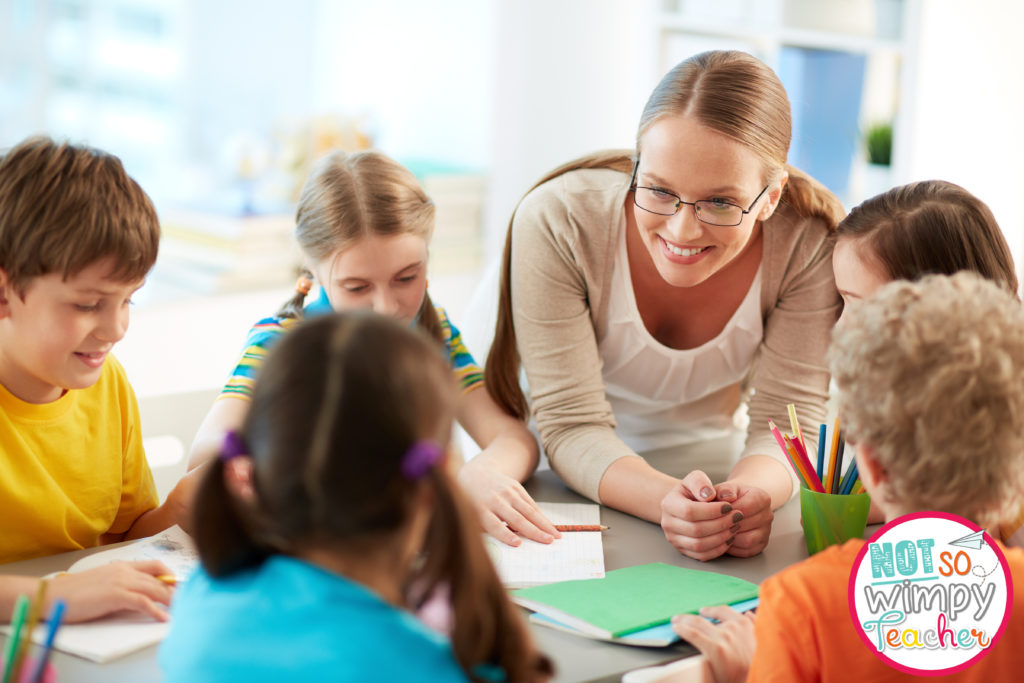 Teacher with glasses leaning in and talking to strengthen her connection with students
