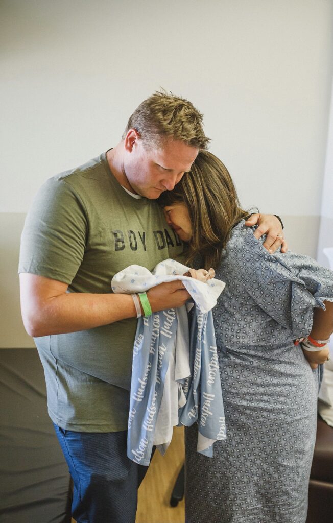 Couple holding baby conceived after infertility and grieving his loss